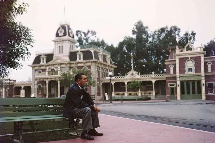Portrait of Walt Disney sitting on a bench in Disneyland